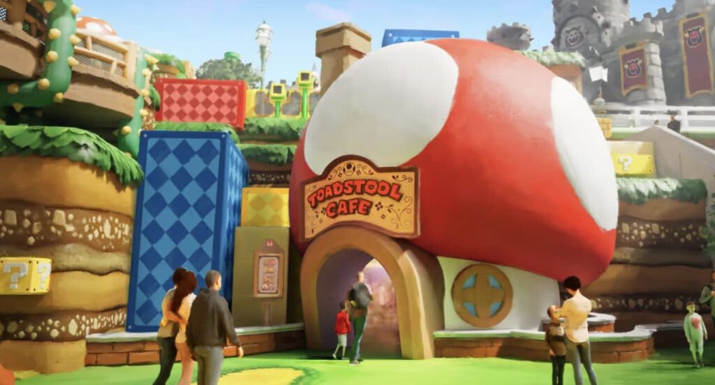 O Toadstool Café mostrado na imagem tem a entrada em forma de cogumelo gigante, como o cogumelo que faz os personagens crescerem nos jogos do universo Mario da Nintendo, e é um café super temático e tecnológico na área Super Nintendo World